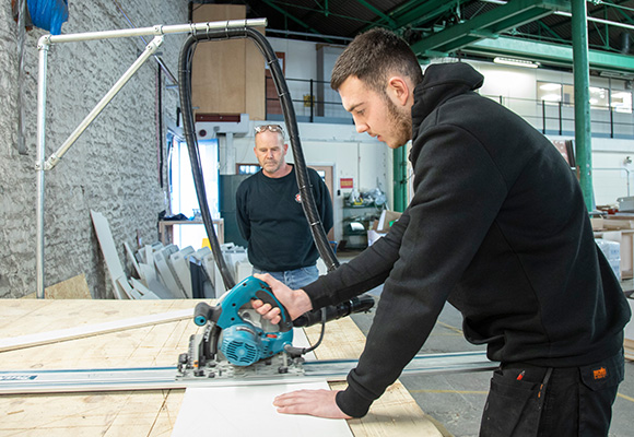 Joinery Apprentice using jigsaw with supervision