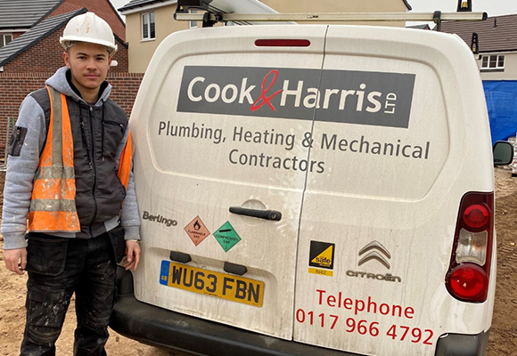 James stood next to works van with high vis vest and helmet.